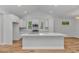Spacious kitchen with white cabinetry, an island, stainless steel appliances, and wood-look floors at 19 Coventry Pl., Pawleys Island, SC 29585