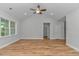 Bright living room with hardwood floors, white trim, ceiling fan, and large windows at 19 Coventry Pl., Pawleys Island, SC 29585