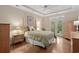 Sunlit bedroom with tray ceiling, wood floors, and private access to the yard through glass panel doors at 192 Berkshire Loop, Pawleys Island, SC 29585