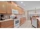 Well-lit kitchen with light wood cabinets, tiled backsplash, and modern appliances with view to dining nook at 192 Berkshire Loop, Pawleys Island, SC 29585