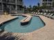 Shallow pool area with a lazy river, brick trim, and lounge chairs at a resort at 2001 S Ocean Blvd. # 621, Myrtle Beach, SC 29577