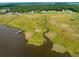An aerial view highlighting the marshland with a wooden walkway to the water and lush greenery at 224 Oak Bay Dr., Georgetown, SC 29440