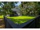 Large backyard features a two-story home, manicured lawn, and a black fence at 224 Oak Bay Dr., Georgetown, SC 29440