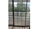 View from the interior of sliding glass doors onto the outdoor balcony with white railing and view of trees at 4639 Wild Iris Dr. # 43-204, Myrtle Beach, SC 29577