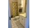 Cozy bathroom features white tile floors, matching vanity, and a shower with a cheerful patterned curtain at 4639 Wild Iris Dr. # 43-204, Myrtle Beach, SC 29577
