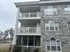 Condo building exterior with gray brick, light blue siding, and screened-in balconies at 4639 Wild Iris Dr. # 43-204, Myrtle Beach, SC 29577