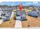 Aerial view of a blue home, showcasing its well-maintained landscaping, driveway and beautiful neighborhood pond at 5606 Whitebark Dr., Myrtle Beach, SC 29577