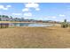 A grassy backyard offers a pond view with community homes in the background on a sunny day at 5606 Whitebark Dr., Myrtle Beach, SC 29577