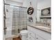 Bathroom with granite countertop, decorative hanging shelves, framed art, and tub with shower at 5606 Whitebark Dr., Myrtle Beach, SC 29577