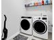 Modern laundry room featuring a front loading washer and dryer set plus storage shelf at 5606 Whitebark Dr., Myrtle Beach, SC 29577