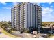 Exterior view of the high-rise condo building showing the ample balconies, signage, and parking at 601 Mitchell Dr. # 801, Myrtle Beach, SC 29577