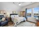 Comfortable bedroom with water views, featuring a ceiling fan and cozy seating area at 100 Marblehead Dr., Little River, SC 29566