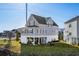 Charming two-story coastal home with a lush green lawn, covered patio, and lovely curb appeal at 100 Marblehead Dr., Little River, SC 29566