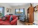 Comfortable living room featuring a red sofa, upholstered chair, built in bookcase, and waterfront view at 100 Marblehead Dr., Little River, SC 29566