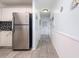 Hallway featuring white walls, stainless steel refrigerator, and gray tile flooring at 108 Ocean Blvd. N # 101, North Myrtle Beach, SC 29582