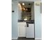 Cozy wet bar with stone countertop, white cabinetry, mini fridge and glass shelving perfect for entertaining at 108 Ocean Blvd. N # 101, North Myrtle Beach, SC 29582