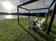 Outdoor seating area with a shade sail, a fire pit, and beautiful views of the lake at 1121 Glossy Ibis Dr., Conway, SC 29526
