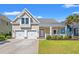 Charming home featuring a welcoming front porch, manicured lawn, and a two-car garage at 1127 East Isle Of Palms Ave., Myrtle Beach, SC 29579
