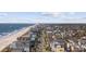 Stunning aerial view of a charming beach neighborhood near the ocean and pier with palm trees at 1210 N Ocean Blvd. # 105, Surfside Beach, SC 29575