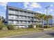 Condo building with three stories and multiple balconies, surrounded by palm trees at 1210 N Ocean Blvd. # 105, Surfside Beach, SC 29575