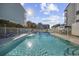 Community pool with lounge chairs and fenced in area, surrounded by palm trees at 1210 N Ocean Blvd. # 105, Surfside Beach, SC 29575