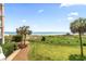 Beautiful ocean view from a lush green lawn lined with palm trees and a pathway at 145 S Dunes Dr. # 109, Pawleys Island, SC 29585