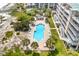 Aerial view of a community pool with chairs and palm trees at 145 S Dunes Dr. # 109, Pawleys Island, SC 29585