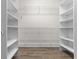 An empty walk-in closet has white storage shelves and wood-look floors at 156 Henry Middleton Blvd., Myrtle Beach, SC 29588