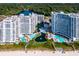 A picturesque aerial view of beachfront condos with multiple pools and a serene pond amid lush landscaping at 161 Seawatch Dr. # 410, Myrtle Beach, SC 29572