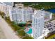 Aerial view of beachfront condos with pools, a tranquil pond, and well-maintained landscaping near the beach at 161 Seawatch Dr. # 410, Myrtle Beach, SC 29572