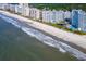 Aerial view of oceanfront condos along a sandy beach, featuring pools and meticulously maintained landscaping at 161 Seawatch Dr. # 410, Myrtle Beach, SC 29572