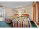Bright bedroom featuring two beds with colorful striped bedspreads and ocean views at 161 Seawatch Dr. # 410, Myrtle Beach, SC 29572