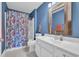 Blue bathroom features a single sink vanity with matching framed mirror and seashell patterned shower curtain at 1631 27Th Ave. N, North Myrtle Beach, SC 29582