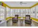 Bright sunroom with large windows, plantation shutters, comfortable seating, and a ceiling fan at 1631 27Th Ave. N, North Myrtle Beach, SC 29582