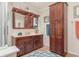 Well-maintained bathroom with wood cabinets, framed mirror, and ceramic tile flooring at 1644 South Waccamaw Dr., Murrells Inlet, SC 29576