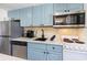 Well-equipped kitchen featuring modern appliances, marble countertops, and blue-gray cabinetry at 2001 S Ocean Blvd. # 1505, Myrtle Beach, SC 29577
