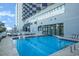Resort-style pool surrounded by lounge chairs and the building's exterior at 2001 S Ocean Blvd. # 1505, Myrtle Beach, SC 29577