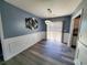 Dining room features wainscoting, modern light fixture, wood-look floors, and access to a patio at 221 Black Bear Rd., Myrtle Beach, SC 29588