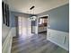 Dining area with stylish light fixture, wainscoting, and wood-look floors leading to the kitchen at 221 Black Bear Rd., Myrtle Beach, SC 29588