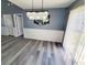 Dining area showcasing a modern chandelier, wainscoting, gray walls, and wood-look flooring at 221 Black Bear Rd., Myrtle Beach, SC 29588