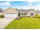 Inviting one-story home with green lawn, complemented by blossoming plants and a spacious two-car garage at 221 Black Bear Rd., Myrtle Beach, SC 29588