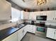 Cozy kitchen features white cabinets, dark countertops, stainless steel appliances, and tiled backsplash at 221 Black Bear Rd., Myrtle Beach, SC 29588