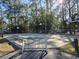 This basketball court includes picnic tables, a fenced in perimeter, and is surrounded by mature trees at 2240 Jackson Circle, Little River, SC 29566
