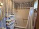 Bathroom including a tub with shower, matching lavender wallpaper, and a shelving unit at 2240 Jackson Circle, Little River, SC 29566