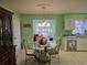 Eat-in dining area with a glass top table and decorated white kitchen, adjacent to the sunroom at 2240 Jackson Circle, Little River, SC 29566