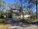 Charming two-story home featuring a carport, manicured lawn, and mature trees providing shade at 2240 Jackson Circle, Little River, SC 29566