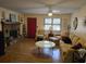 Cozy living room features a brick fireplace, wood flooring, and natural light from the window at 2240 Jackson Circle, Little River, SC 29566