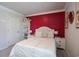 This bedroom showcases a cheerful red accent wall, and a cozy bed centered between two nightstands at 228 Carolina Lakes Blvd., Myrtle Beach, SC 29588
