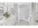 Sleek bathroom with double vanity, modern fixtures, and a tiled walk-in shower at 2404 Watershed Way, Longs, SC 29568