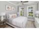 Serene bedroom featuring a bed with white linens, two windows and gray walls at 2404 Watershed Way, Longs, SC 29568